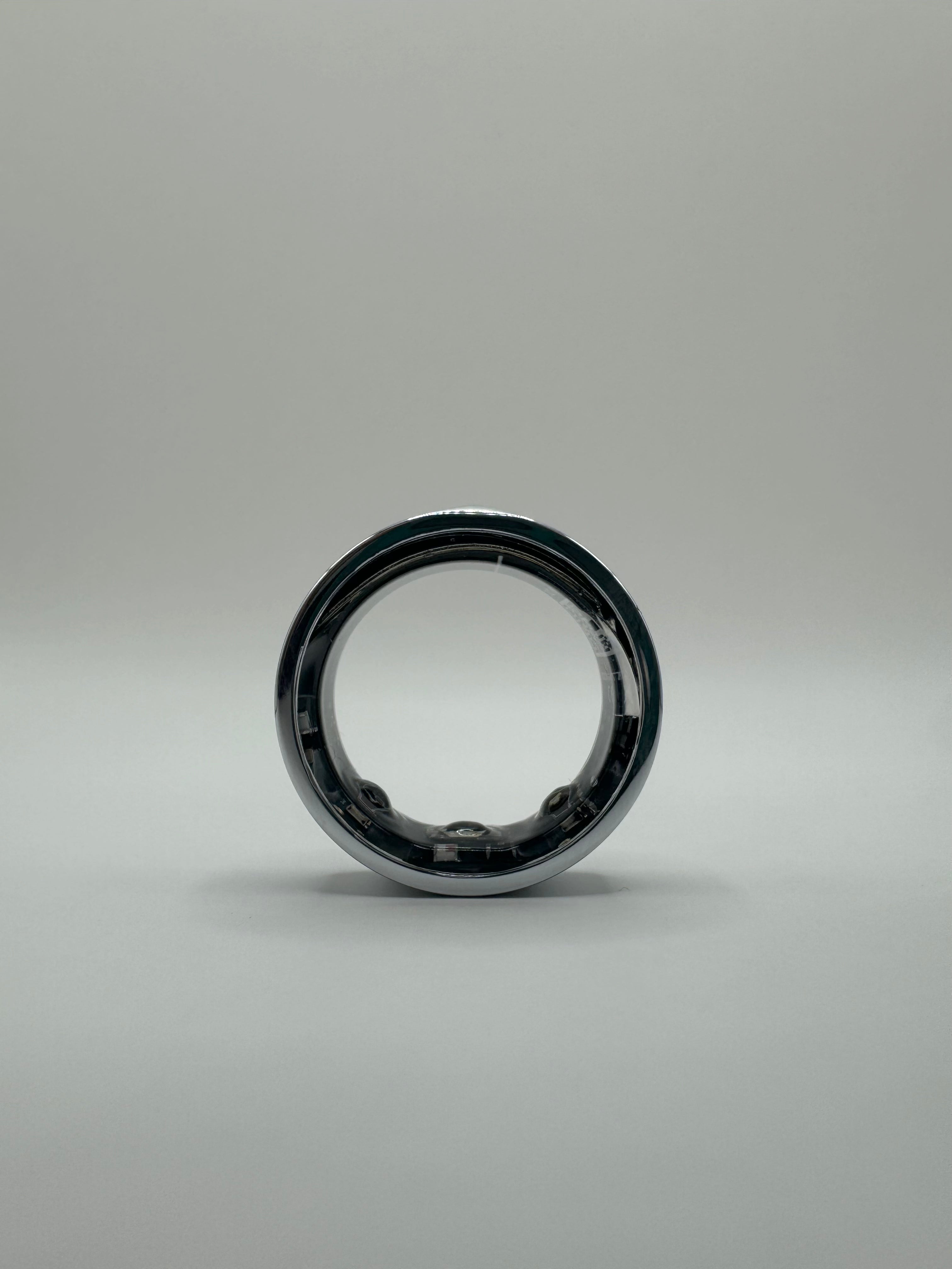 ViraSync Smart Ring i sølvfarve, ViraSync Smart Ring i sort farve, ViraSync Smart Ring i opladningsdock, ViraSync Smart Ring båret på pegefinger under træning, ViraSync Smart Ring viser søvndata på tilhørende app, ViraSync Smart Ring måler puls og iltmætning i realtid, ViraSync Smart Ring synkroniserer med smartphone via Bluetooth, ViraSync Smart Ring sporer aktivitet og hvileperioder, ViraSync Smart Ring overvåger søvnkvalitet og søvnfaser, Person bærer ViraSync Smart Ring under yogaøvelse, ViraSync Smart